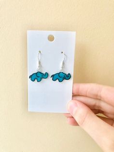 Minimalist HANDMADE Elephant Earrings! These eccentric earrings come in a vibrant blue or pink and with either silver,black or gold earring charm! Please note-  All my products are handmade and made to order so there maybe slight defects in each version Such as-  Small airbubbles Slight differences in coloration than in photo By purchasing this product you agree to accept any slight differences from the photo.  Any imperfections among products and sure to be very minor and unnoticeable. If you have any problems with the quality, or you receive your product broken, please let me know and i'll resolve the issue. Please leave me a message alongside the order (you should see an option to leave a message while placing your order in the cart) what color hook you would like for your earrings. - S Trendy Blue Sterling Silver Earrings, Everyday Blue Earrings With Ear Wire, Nickel Free Blue Earrings For Everyday, Blue Nickel-free Earrings For Everyday, Blue Nickel-free Everyday Earrings, Minimalist Blue Earrings With Ear Wire, Blue Dangle Plug Earrings With Ear Wire, Shrinky Dink Keychain, Shrinky Dink Crafts