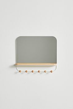 a mirror mounted to the side of a wall with three balls hanging from it's sides