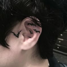 a person with ear piercings that have bats on them