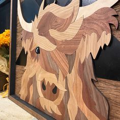 a wood carving of a buffalo head on a wooden door with flowers in the background