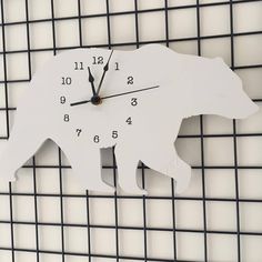 a clock with a bear design on the face and numbers is hanging on a wall