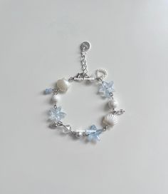 a bracelet with seashells and pearls on it