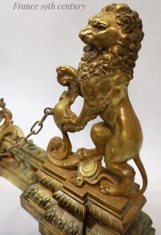 a golden lion statue on top of a wooden table next to a white background with the words france 19th century