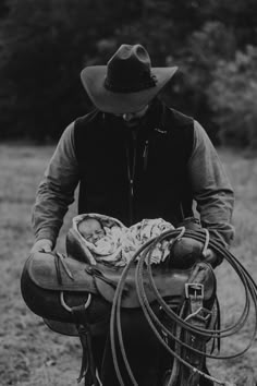 black and white photograph of a cowboy holding a baby