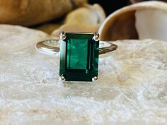 This classic 4 prong setting contains a beautiful 4.00ct. lab created emerald cut emerald. The emerald cut stone measures approximately 10x8mm. The ring is available in sterling silver, and 14k white, yellow, or rose gold. This ring makes a great promise or engagement ring. Emerald is the birthstone for May. Please send me a message if you need a size not listed. All items are handmade by me in my shop in Woodbridge, NJ. Please message me with any questions. Fine Jewelry Solitaire Emerald Ring With Rectangular Stone, Emerald Cut Diamond Ring For May Birthstone, Emerald Solitaire Ring With Rectangular Stone, Solitaire Emerald Ring With Rectangular Stone, May Birthstone Emerald Cut Emerald Ring, Classic Emerald Ring With Rectangular Stone, Classic Green Emerald Ring With Rectangular Stone, Emerald Cut Birthstone Emerald Ring, Solitaire Emerald Ring With Radiant Cut