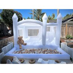 an inflatable bed with a teddy bear on the top and rocks below it