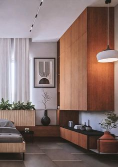 a bed sitting in a bedroom next to a wooden cabinet under a light hanging from a ceiling