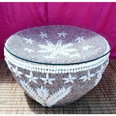 a decorative glass bowl with white flowers on the bottom and bead trimmings