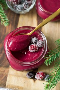 cranberry curd in a jar on a cutting board with berries and pine branches