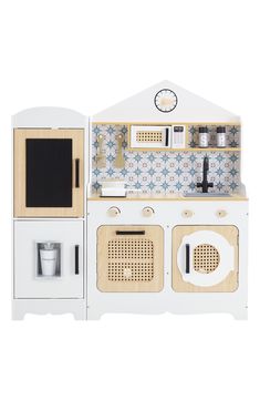 a toy kitchen with white appliances and blue wallpaper