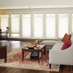 a living room filled with furniture and windows covered in blind shades on the windowsill