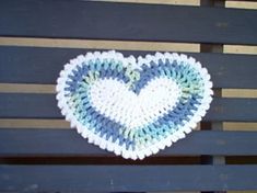 a crocheted heart sitting on top of a wooden bench