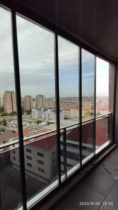 an empty room with large windows looking out at the city below and buildings in the distance