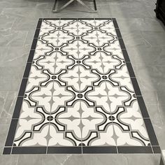 a black and white tiled floor with a bench in the backgrouf area