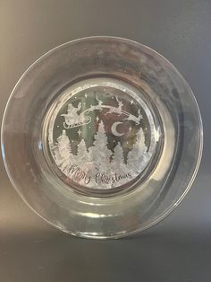 a glass plate with a merry christmas design on the front and bottom, sitting on a silver surface