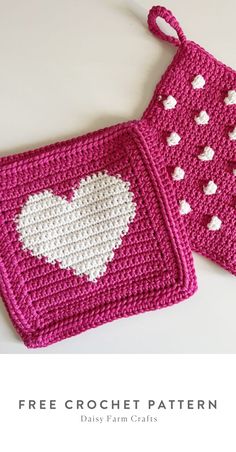 two crocheted potholders with hearts on them, one is pink and the other is white