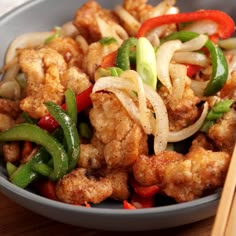 a bowl filled with meat and vegetables next to chopsticks