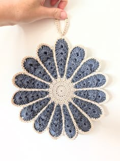 a crocheted blue and white doily hanging from a hook on a wall