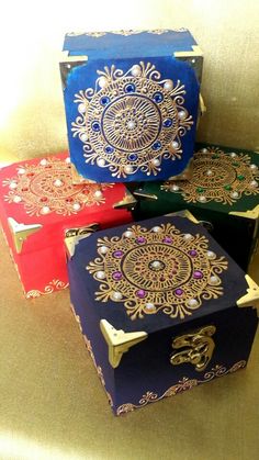 three colorful boxes with designs on them sitting on a table