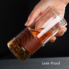 a person pouring tea into a glass cup