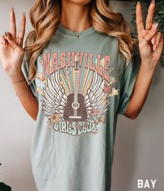 Wear this super cute Comfort Colors Nashville shirt on your next girls road trip, to your next country concert, at your upcoming Nashville Bachelorette party, or just wear it as a bold rock and roll fashion statement! Any way you choose to wear it, you'll be looking cool and comfortable! Comfort Colors Retro Nashville Tennessee Shirt, Nashville Girls Trip Nashville Graphic Tee, Road Trip Tshirt, Nashville Bachelorette Shirts SIZE UP for an OVERSIZED FIT (see size chart in listing photos). Our sh Nashville Tshirt Ideas, Country T Shirts, Western Tshirts, Nashville Graphic, Western T Shirts, Western Tees, Nashville Bachelorette Shirts, Girls Road Trip, Nashville Girls Trip