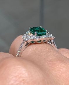 Emerald statement cocktail ring is a great way to create an elegant, princess-like look. The center stone is emerald cut shape and has gorgeous facets. For extra sparkle, 2 Emerald cut side 0.30ctw diamonds and has been framed by 48 round brilliant cut 0.37ctw diamonds forming a beautiful halo around. Metal: 18K white goldDiamond Weight : (48) 0.37ctw Side Diamonds: (2) 0.30ctwEmerald Weight: 1.64ctWidth: 13mm X 15mm Emerald: W 8 mm X L 5.7mm Estimated production time is 4 - 5 weeks Diamond Cocktail Ring, Diamond Cocktail Rings, Green Emerald, Emerald Diamond, Cocktail Ring, Round Brilliant Cut, Cocktail Rings, Emerald Cut, Round Brilliant