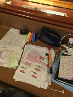 the desk is cluttered with papers, pens, and other things to write on