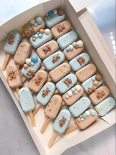 a box filled with lots of cookies on top of wooden sticks in the shape of animals