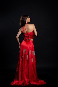 Adding a touch of royal elegance and grace to weddings and festivities, this stunning scarlet-red lehenga is a must-have! The cupro satin fabric is soft and lightweight, making it perfect for twirling around the dance floor. The intricate hand-embroidered mirror work adds a unique sparkle to your look.Details Neckline: Halter neck Material: Cupro satin Lining: Cotton-polyester Made in India Material This outfit is made with cupro satin; the fabric is made from cotton linter wasteIt is a sustainable alternative to polyester Elegant Red Raw Silk Pre-draped Saree, Festive Satin Pre-draped Saree For Formal Occasions, Red Art Silk Pre-draped Saree For Reception, Satin Pre-draped Saree With Pallu For Reception, Satin Pre-draped Saree For Wedding, Red Silk Dress With Cutdana, Red Silk Dress With Cutdana Detail, Floor-length Cutdana Choli For Evening, Elegant Satin Lehenga For Evening