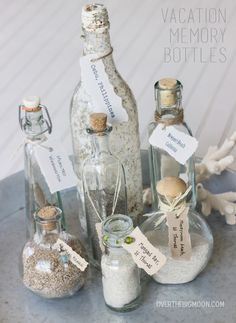 several bottles with sand and sea shells in them