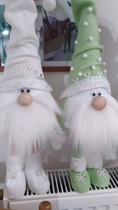 two white and green gnomes standing next to each other