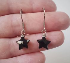 "These cute little star shaped Black Onyx stones are so simple and dainty. They are perfect for anyone who loves stars or astrology! Made with 100% stainless steel 24 gauge wire and earring hooks. They hang approximately 0.75\" down from earring hook.  The earrings will come on an earring card with plastic earring backs, and packaged in a charming box, perfect for easy gifting! Onyx is a variety of Chalcedony that can occur in a variety of colors and often contains bands. It has a long history o Cute Black Earrings, Black Star-shaped Earrings For Party, Black Star Charm Earrings, Black Star-shaped Earrings For Pierced Ears, Black Star Shaped Earrings As Gift, Star-shaped Crystal Earrings For Gifts, Nickel-free Black Star Earrings, Black Star-shaped Nickel-free Earrings, Single Star-shaped Crystal Earring As Gift