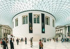 many people are walking around in a large building with high ceilings and glass ceilinging