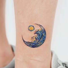 a small tattoo on the ankle of a woman's foot with a wave and sun