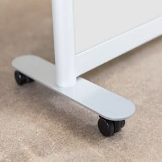 a white bed frame sitting on top of a carpeted floor next to a wall