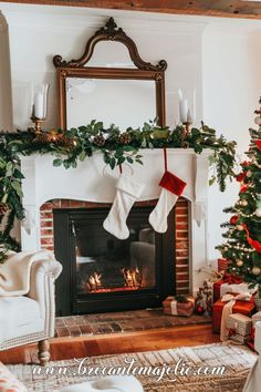 a fireplace with stockings hanging from it's mantle next to a christmas tree and fire place