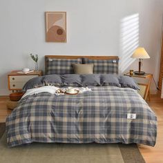 the bed is made with plaid sheets and pillows