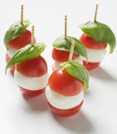 small tomatoes and mozzarella on toothpicks with green leafy toppings