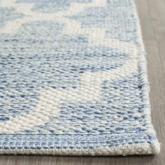 a blue and white rug on the floor with a wooden floor in front of it