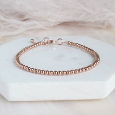 "Rose Gold Bead Minimalist Bracelet Beautiful dainty rose gold-filled bead (3mm) bracelet with a rose gold plated clasp and completed with a 1\" extender rose gold-filled chain. This bracelet is created with rose gold-filled beads and not plated beads. Each bracelet will arrive in a box tied with a ribbon perfect for gift giving. Also, included will be a polish pad, anti-tarnish bag with an anti-tarnish tab for storing. Please read my policies before placing an order. Convo me if you have any qu Minimalist Rose Gold Jubilee Bracelet, Adjustable Rose Gold Beaded Bracelets, Elegant Rose Gold Beaded Bracelets With Tiny Beads, Elegant Rose Gold Charm Bracelet With Round Beads, Elegant Rose Gold Bead Charm Bracelet, Elegant Adjustable Rose Gold Rosary Bracelet, Delicate Rose Gold Beaded Bracelet, Delicate Rose Gold Beaded Bracelets With Round Beads, Elegant Rose Gold Jewelry With Tiny Beads