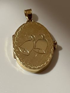 This hand-made oval locket is as sentimental and unique as it gets. It is a perfect baby shower or a Communion present. It is made of 14 karat gold. It is both beautiful and functional. Most lockets can hold 2 pictures but this one can hold 4 special photos close to your, or your loved one's heart! The photos are easy to slip through slots at top of locket. It is hard to match the workmanship of this locket and it's engraving. It was crafted by a very talented jeweler in the NYC jewelry district between 1970 - 1980. Lockets are his legacy and his remaining inventory is being sold on this site. Most are one of a kind and will not be available after it is sold. The best jewelers are in awe of the workmanship and you will always get compliments. This precious locket and can easily become a he Heirloom Yellow Gold Locket Necklace With Charms, 14k Gold Yellow Gold Locket Necklace With Charms, 14k Yellow Gold Locket Necklace For Anniversary, 14k Yellow Gold Locket Necklace With Charms, 14k Gold Hallmarked Locket Necklace For Keepsake, Gold Oval Link Locket Necklace For Anniversary, 14k Gold Locket Necklace With Oval Pendant For Anniversary, Heirloom 14k Gold Locket Necklace For Wedding, Classic Oval Locket Necklace Stamped 14k