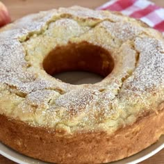 an apple cake on a plate with apples in the background and text overlay that reads italian apple cake