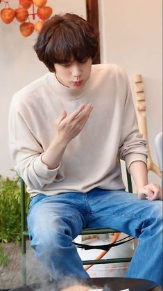 a young man sitting on top of a chair