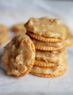 a stack of cookies covered in frosting on top of a white table cloth next to some crackers