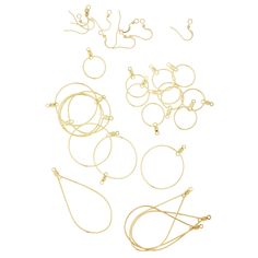 several pairs of gold colored metal rings and earring wires on a white background with clippings