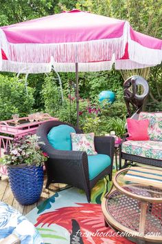 an outdoor patio with colorful furniture and umbrella