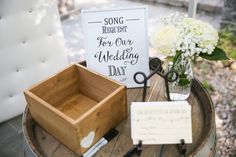 a wooden box sitting on top of a table next to a vase filled with flowers