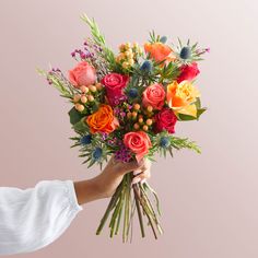 a person holding a bouquet of colorful flowers