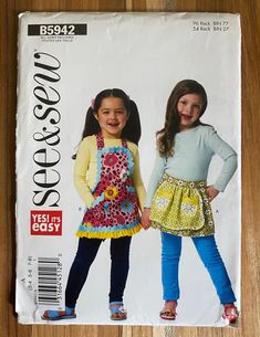 This See & Sew kid's apron pattern #B5942 is an uncut kid's apron pattern for sizes 3-4, 5-6, or 7-8. The 'easy sewing' kid's aprons comes with 2 options but eliminating the overskirt on View A increases it to 3. These aprons leave lots of room for fun fabrics and embellishments. A finished apron makes a fun yet inexpensive child's birthday gift. Make a half dozen aprons and donate to your child's classroom! Child Apron Pattern, Girls Apron, Upcycling Clothing, Apron Patterns, Sewing Templates, Girl Apron, Craft Apron, Apron Pattern