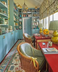 a living room filled with lots of furniture next to a window covered in bookshelves